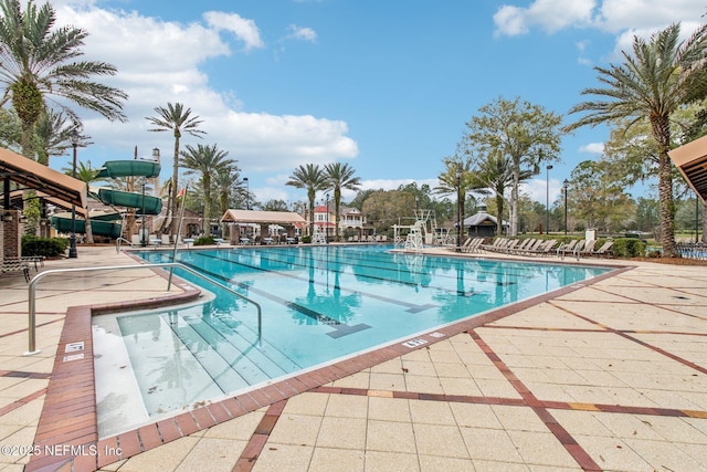 pool with a water slide and a patio