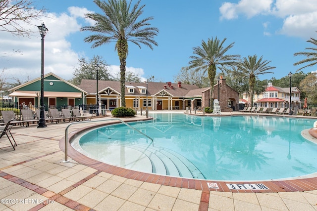 community pool with fence and a patio