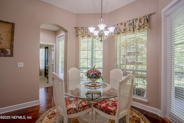 4250 Eagle Landing Pkwy, Orange Park, FL 32065 - dining area featuring arched walkways, a chandelier, healthy amount of natural light, and wood finished floors