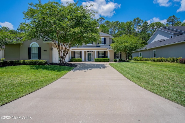 4250 Eagle Landing Pkwy, Orange Park, FL 32065 - view of front facade with concrete driveway, a front lawn, stucco siding, and a garage