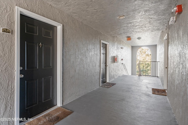 hallway with concrete floors and a textured ceiling