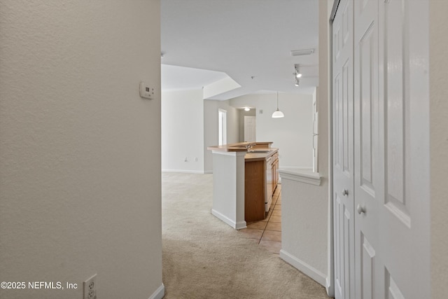 hall featuring light colored carpet and sink