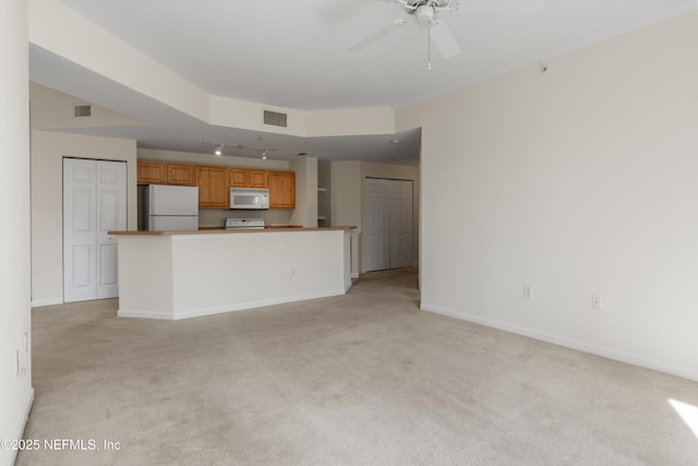 unfurnished living room featuring light carpet and ceiling fan