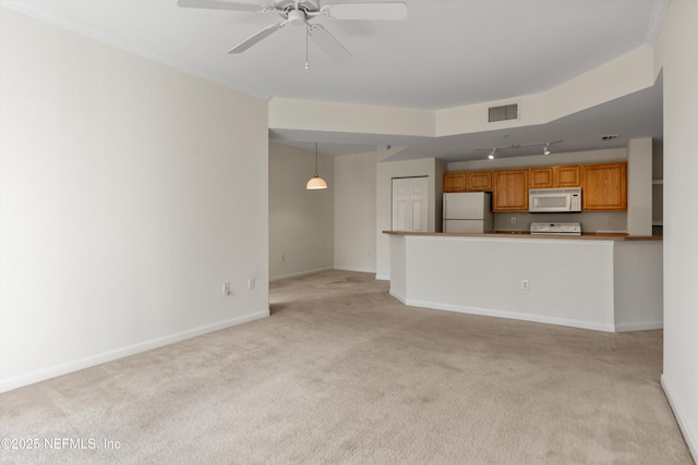 unfurnished living room with light colored carpet, rail lighting, and ceiling fan