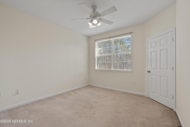 carpeted spare room with ceiling fan