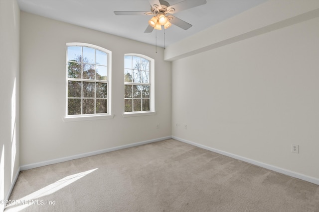 carpeted spare room with ceiling fan