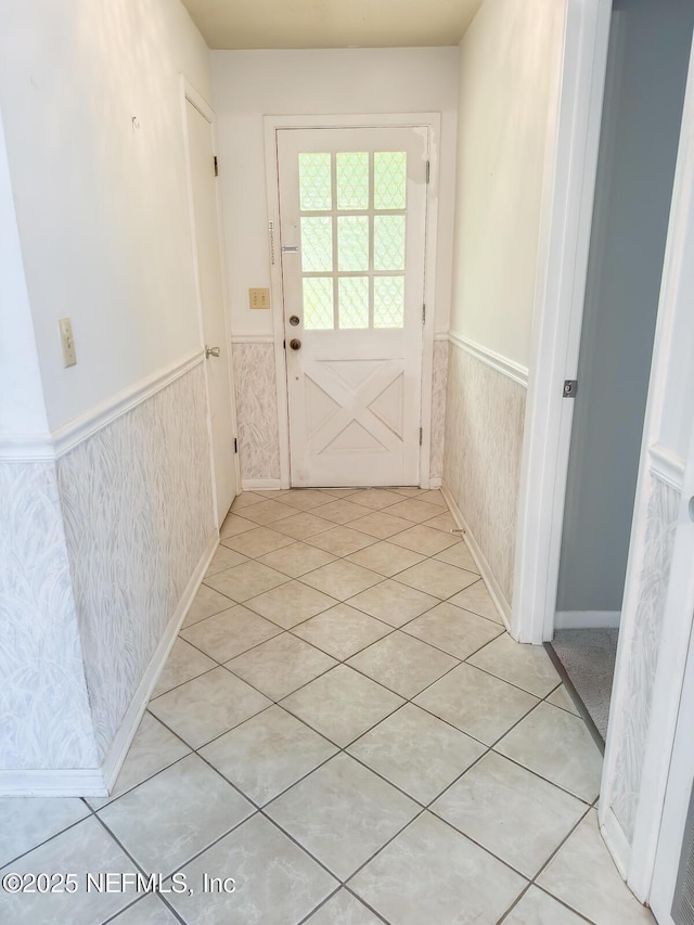 doorway to outside with light tile patterned flooring