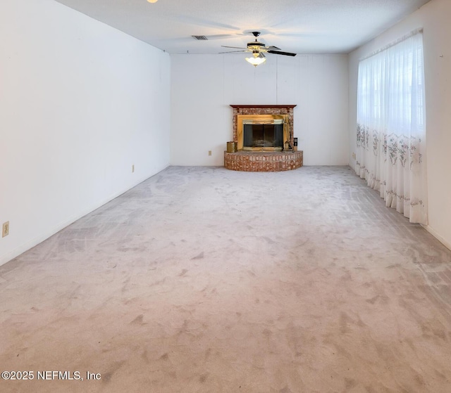 unfurnished living room with a fireplace, ceiling fan, and carpet flooring