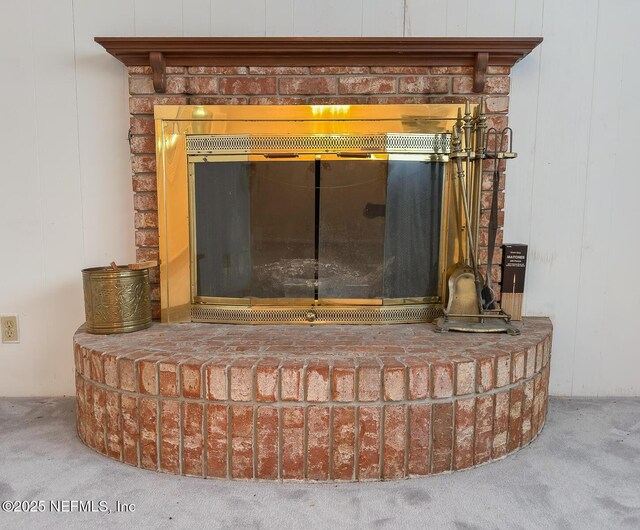 interior details featuring carpet and a brick fireplace