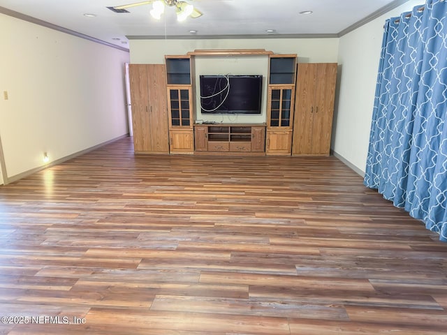 unfurnished living room with hardwood / wood-style flooring and crown molding