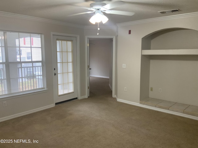 spare room featuring crown molding, ceiling fan, and carpet