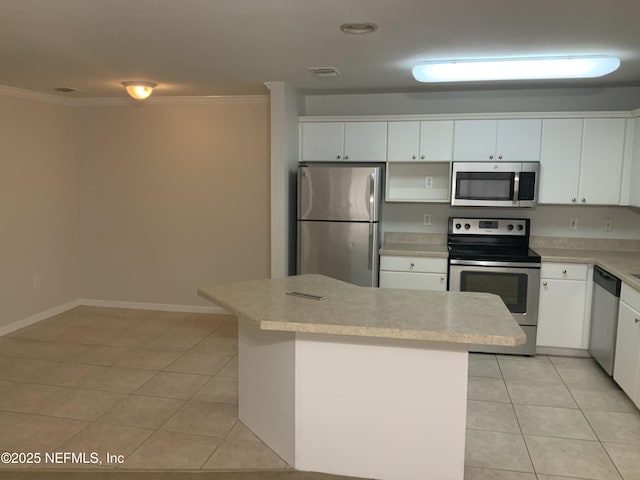 kitchen with light tile patterned floors, crown molding, stainless steel appliances, and white cabinets