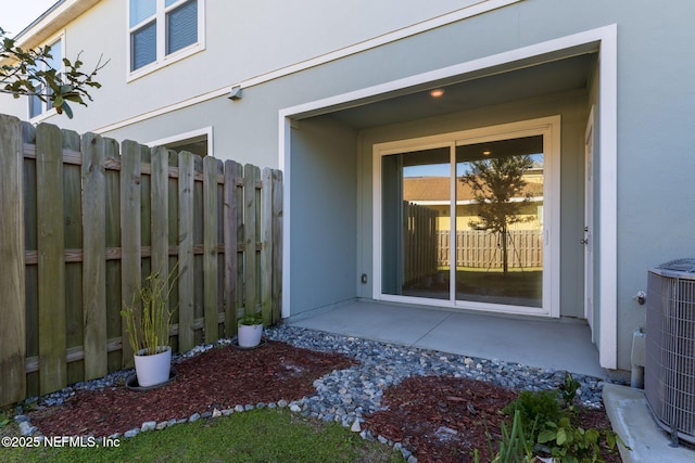 entrance to property featuring central AC unit and a patio area