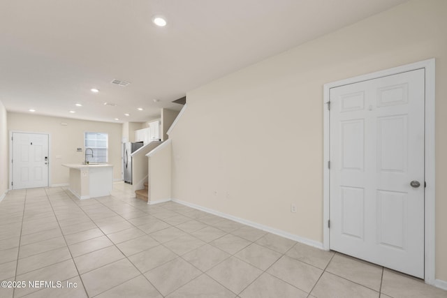 empty room featuring light tile patterned flooring and sink