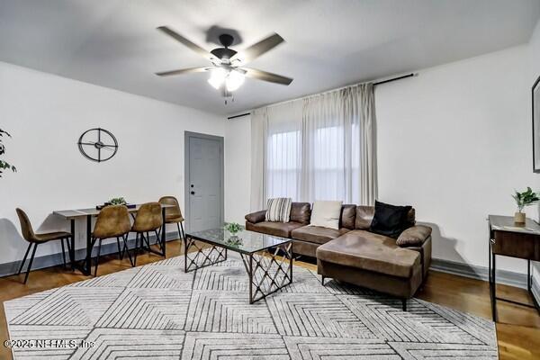 living room featuring hardwood / wood-style floors and ceiling fan