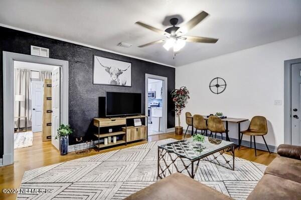 living room featuring ceiling fan and light hardwood / wood-style floors