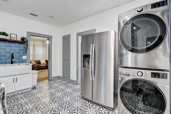 laundry area with stacked washer / dryer and sink