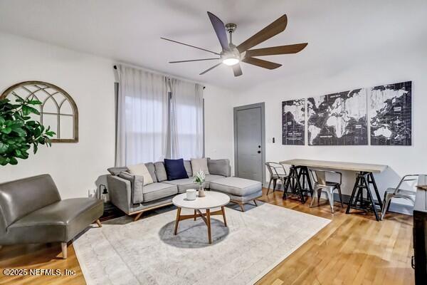 living room featuring wood-type flooring and ceiling fan