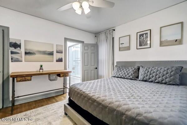 bedroom with dark hardwood / wood-style floors and ceiling fan