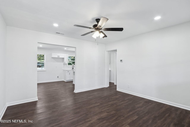 unfurnished room featuring dark wood-type flooring and ceiling fan