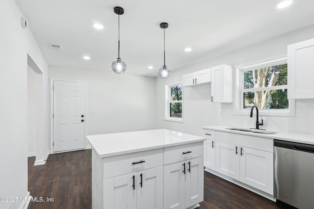 kitchen with decorative light fixtures, tasteful backsplash, sink, white cabinets, and stainless steel dishwasher