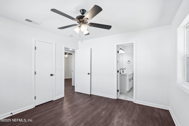 unfurnished bedroom with dark hardwood / wood-style flooring, sink, ceiling fan, and ensuite bathroom