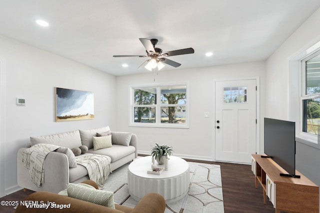 living room featuring ceiling fan and dark hardwood / wood-style flooring