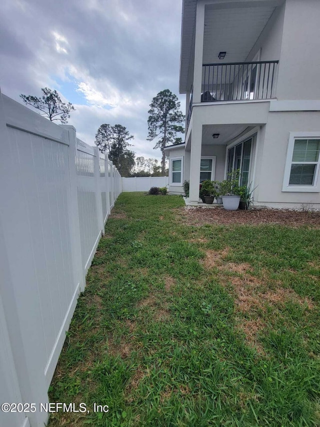 view of yard with a balcony