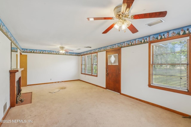 unfurnished living room featuring ceiling fan and carpet flooring