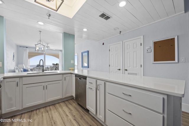 kitchen featuring sink, decorative light fixtures, dishwasher, kitchen peninsula, and light stone countertops