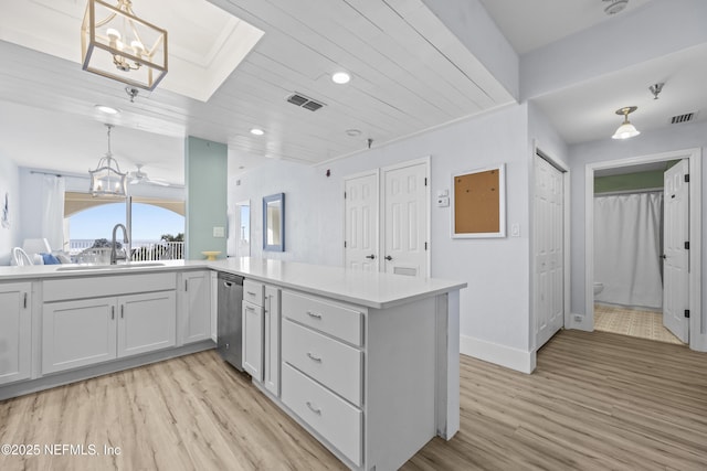 kitchen featuring hanging light fixtures, stainless steel dishwasher, and kitchen peninsula