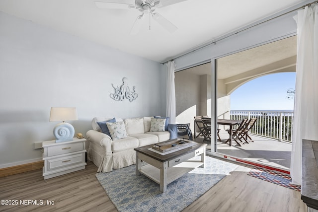 living room featuring a water view, ceiling fan, and hardwood / wood-style floors