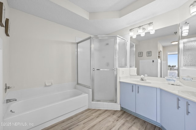 bathroom with vanity, hardwood / wood-style flooring, plus walk in shower, and a textured ceiling