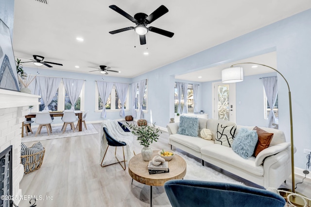 living room featuring light hardwood / wood-style floors and a brick fireplace