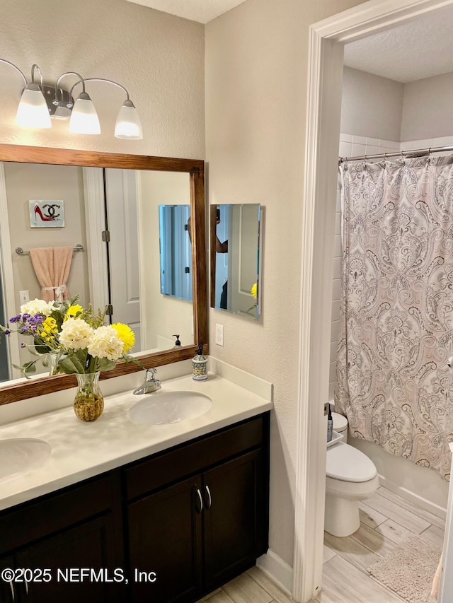 full bathroom featuring shower / bathtub combination with curtain, vanity, and toilet