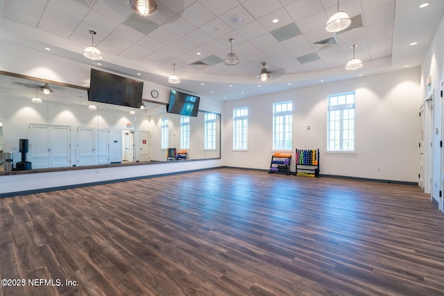 exercise area featuring dark wood-type flooring, a paneled ceiling, and a tray ceiling