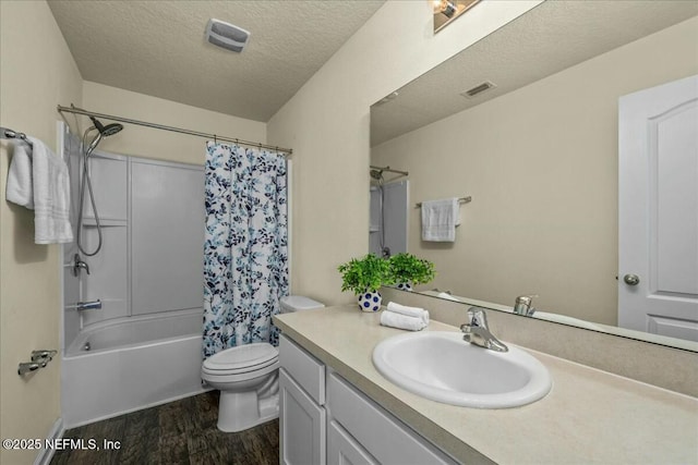 full bathroom with hardwood / wood-style flooring, shower / bath combo, vanity, a textured ceiling, and toilet