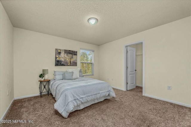 carpeted bedroom featuring a spacious closet and a textured ceiling