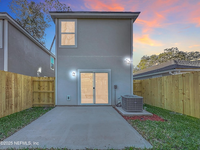 back house at dusk with a patio and central air condition unit