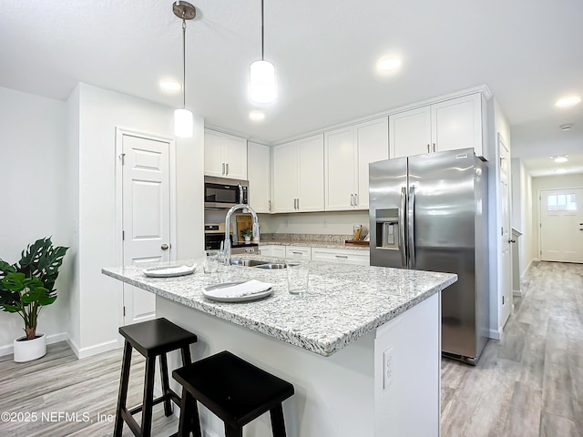 kitchen featuring white cabinetry, an island with sink, appliances with stainless steel finishes, and sink