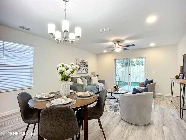 dining space featuring ceiling fan with notable chandelier and light hardwood / wood-style floors