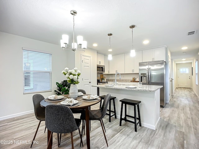 dining space featuring a chandelier and light wood-type flooring