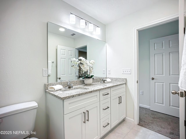 bathroom featuring vanity, tile patterned flooring, and toilet