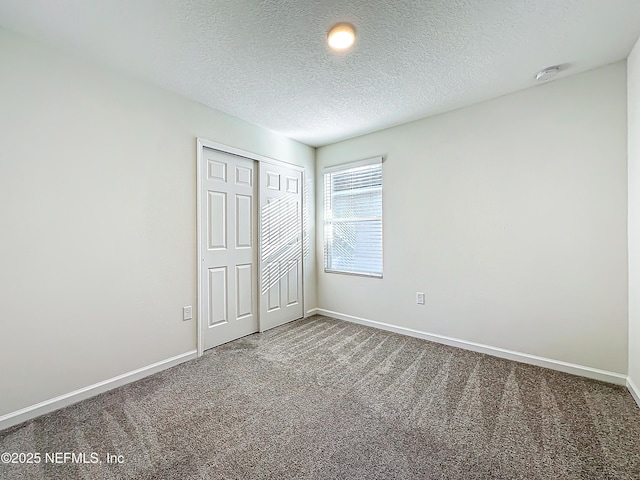 unfurnished bedroom featuring a closet, a textured ceiling, and carpet flooring