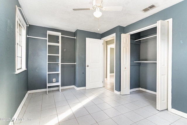 unfurnished bedroom featuring light tile patterned floors, a closet, and ceiling fan