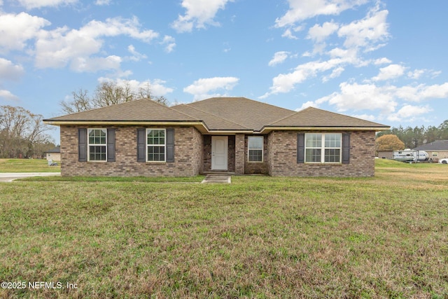 ranch-style home with roof with shingles, a front lawn, and brick siding