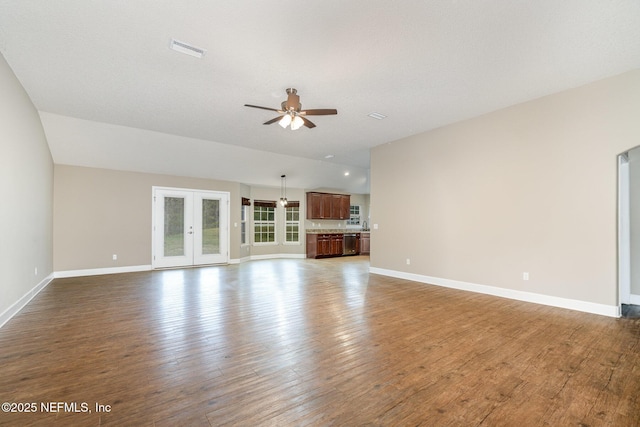 unfurnished living room with a ceiling fan, visible vents, baseboards, and wood finished floors