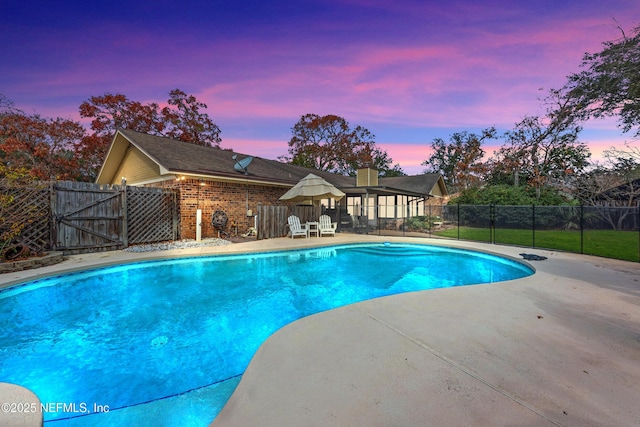 pool at dusk with a patio