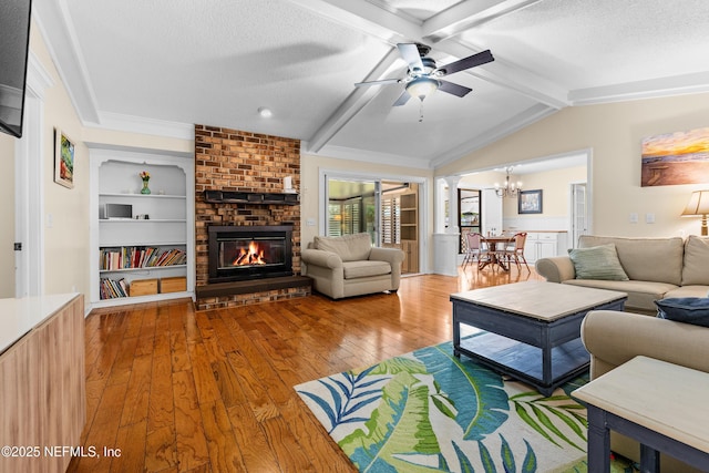 living room featuring built in features, a fireplace, wood-type flooring, vaulted ceiling with beams, and a textured ceiling