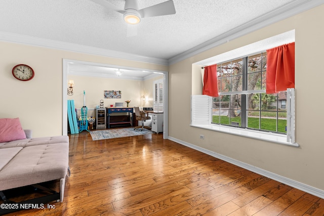 living room featuring ceiling fan, crown molding, wood-type flooring, and a textured ceiling